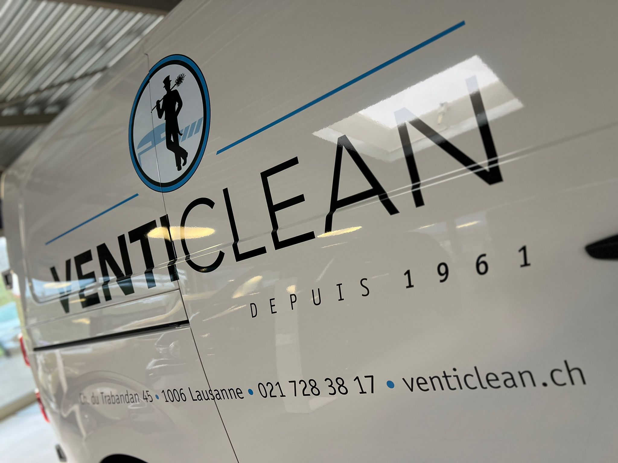 a white van with black text and blue text