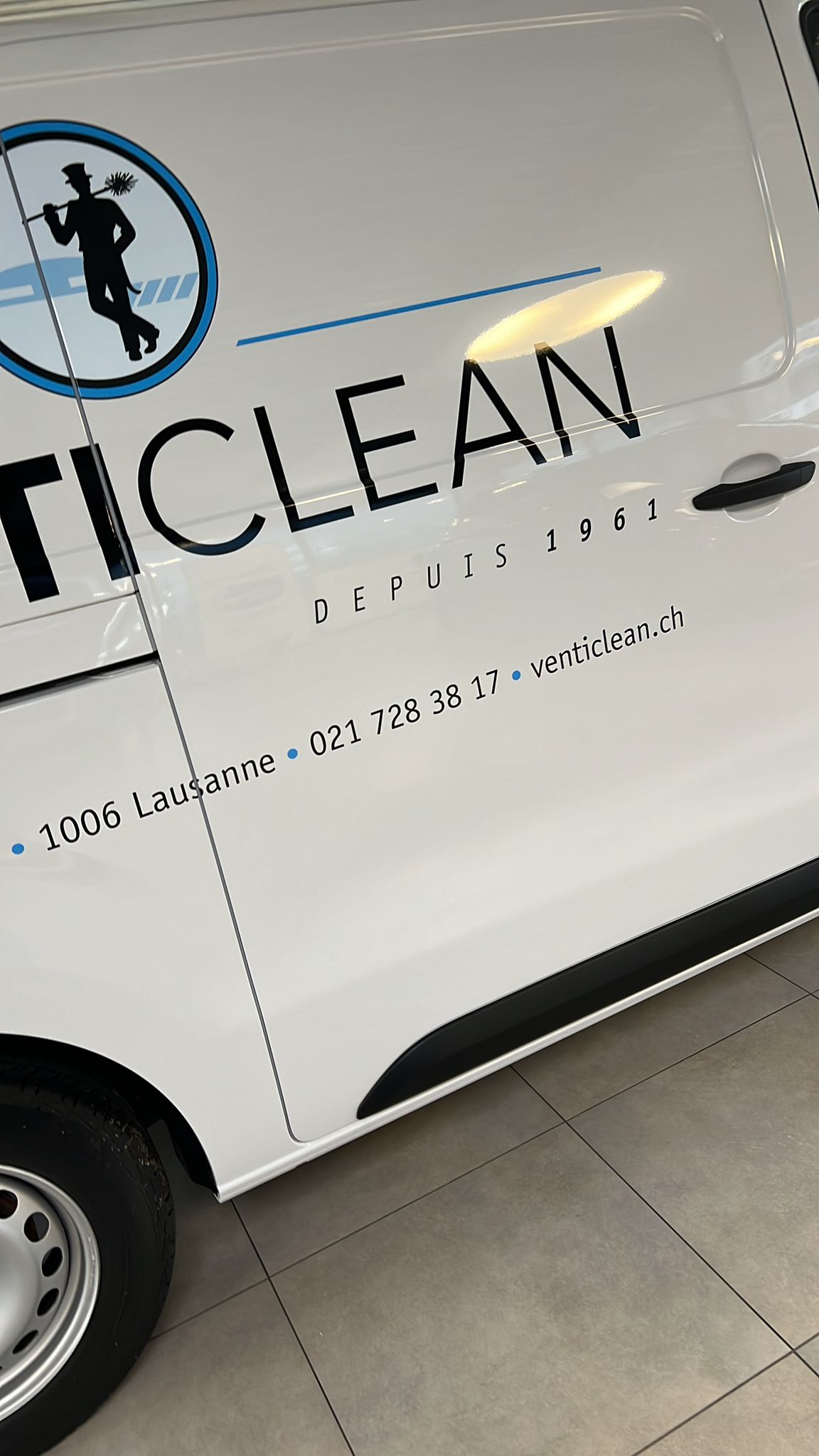 a white car with black text and blue text on it