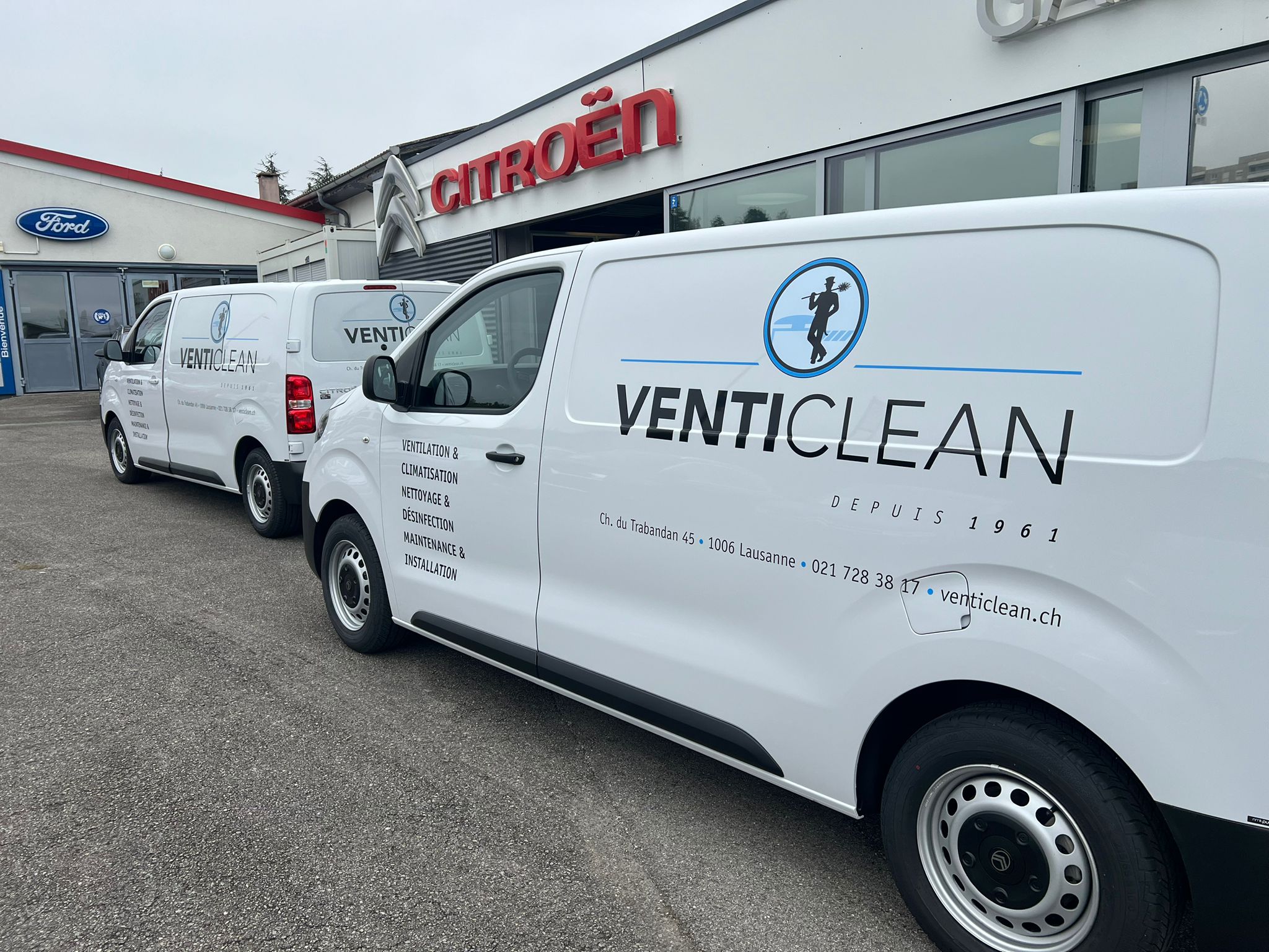 a row of white vans with black text on them