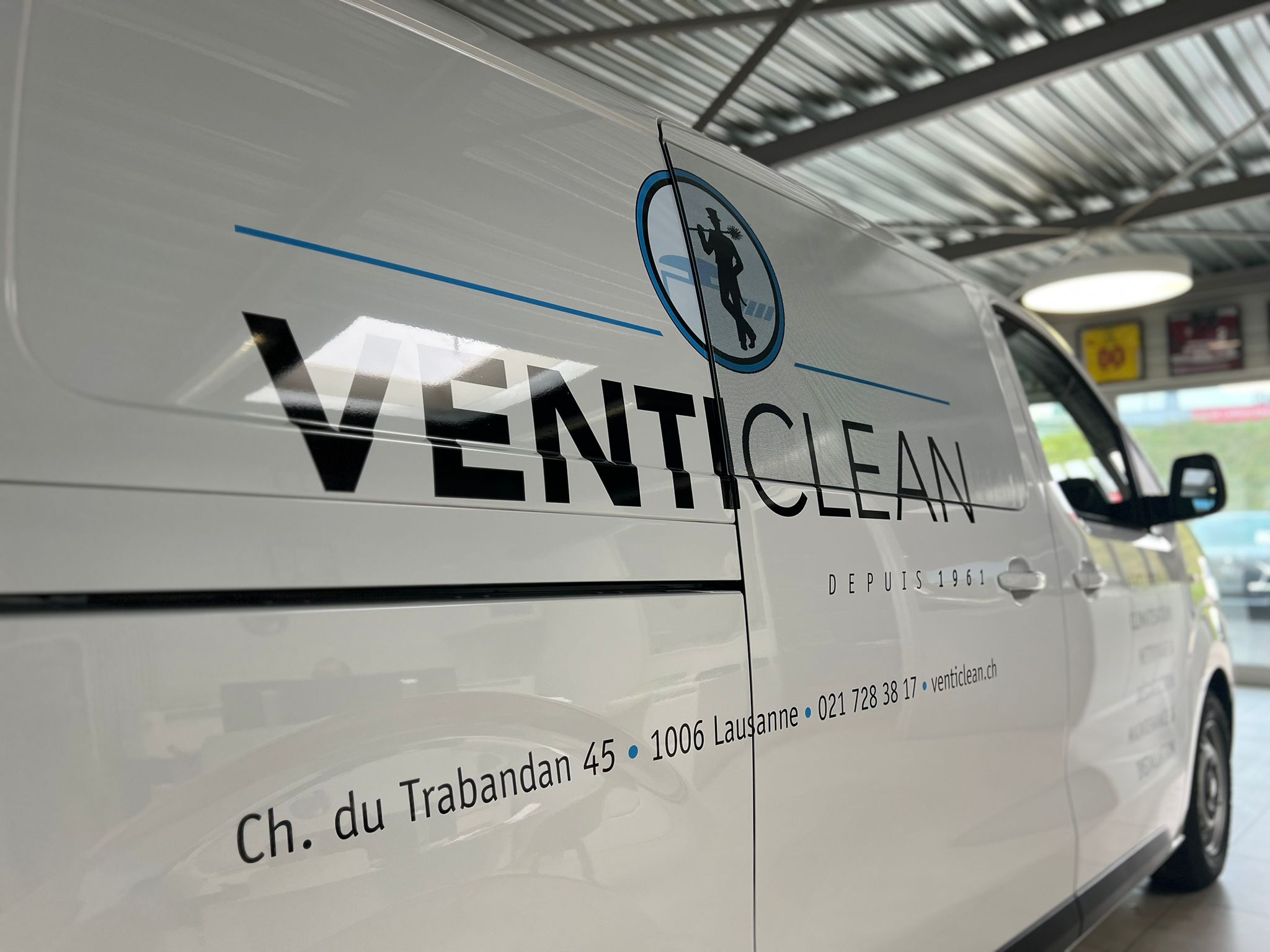 a white van with black text and blue text