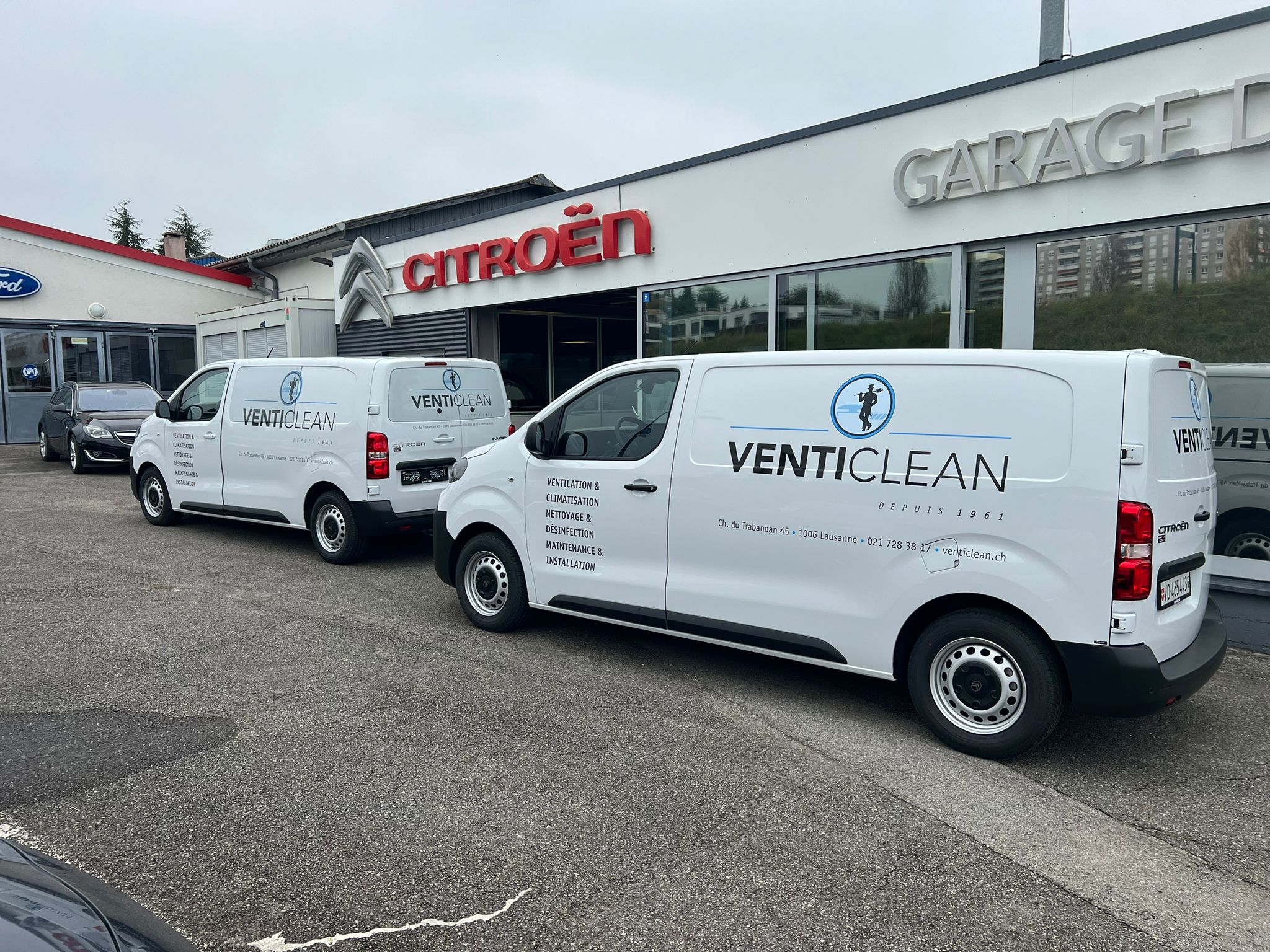 a group of white vans parked in front of a building