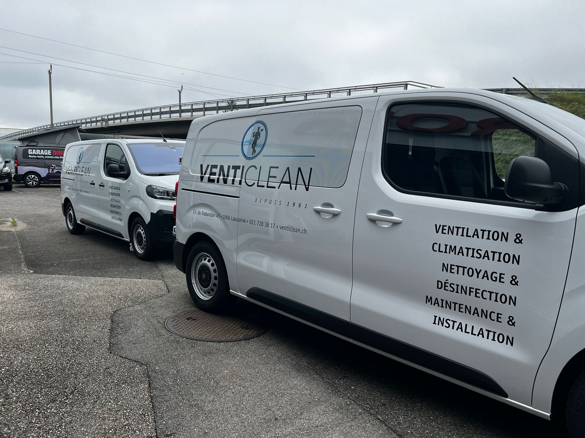 a group of white vans parked on a road
