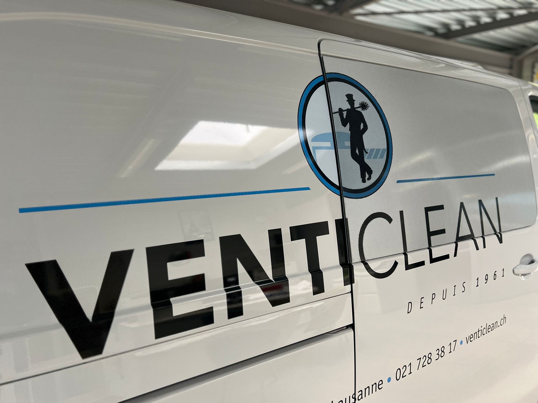 a white van with black text and blue text